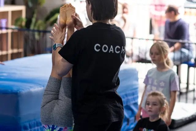 Modbod Gymnastics coach guiding young athlete during class